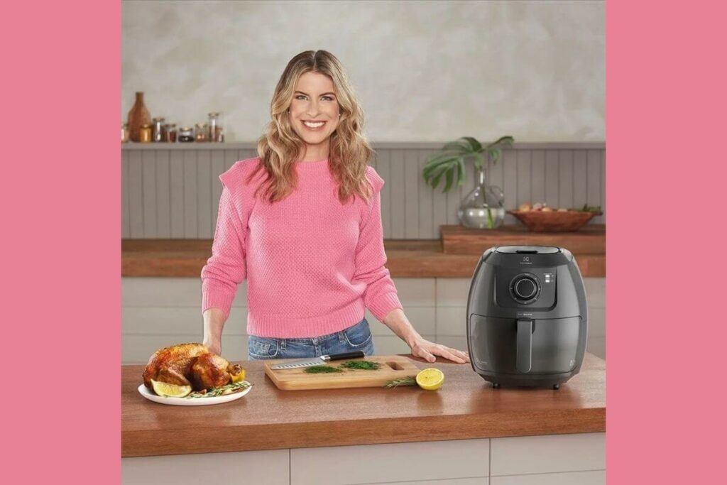 A Rita Lobo toda sorridente com um frangão assado do seu lado esquerdo e do lado direito a dignissima air fryer do qual estamos falando
Air fryer Electrolux Rita Lobo Eaf50 5L é boa?